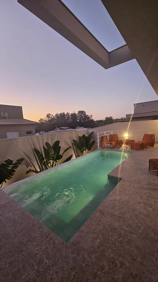 Piscina residencial com borda em deck ao entardecer